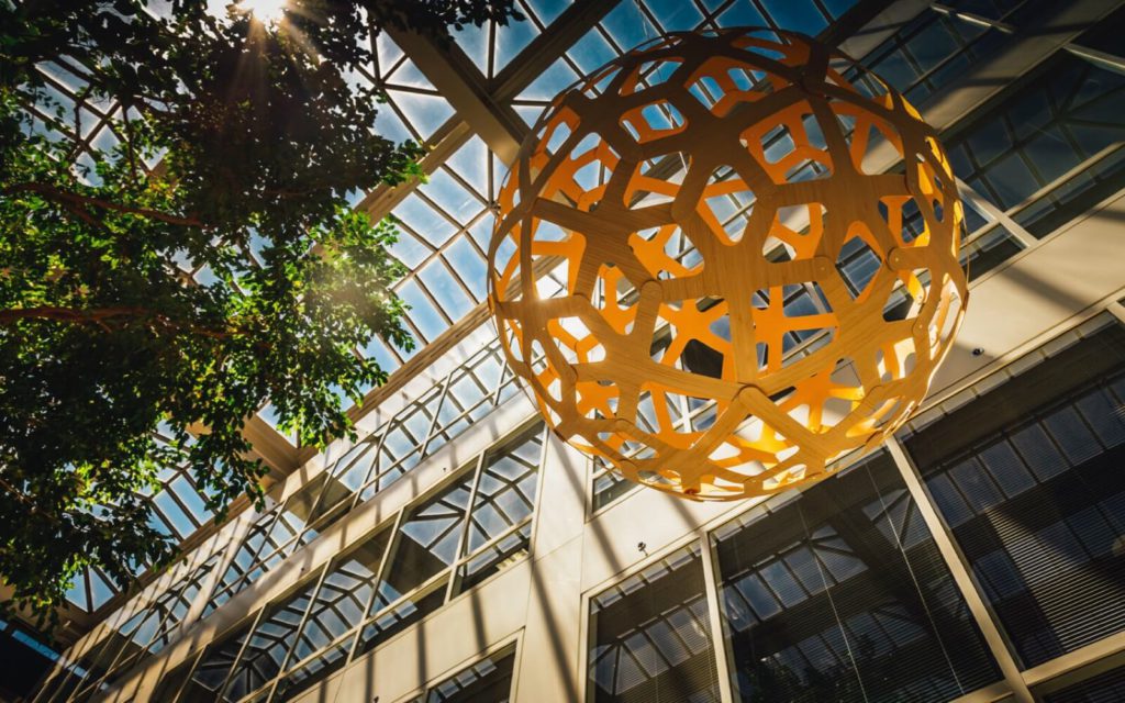 a yellow artistic sphere hanging from the atrium of the schaumburg corporate center