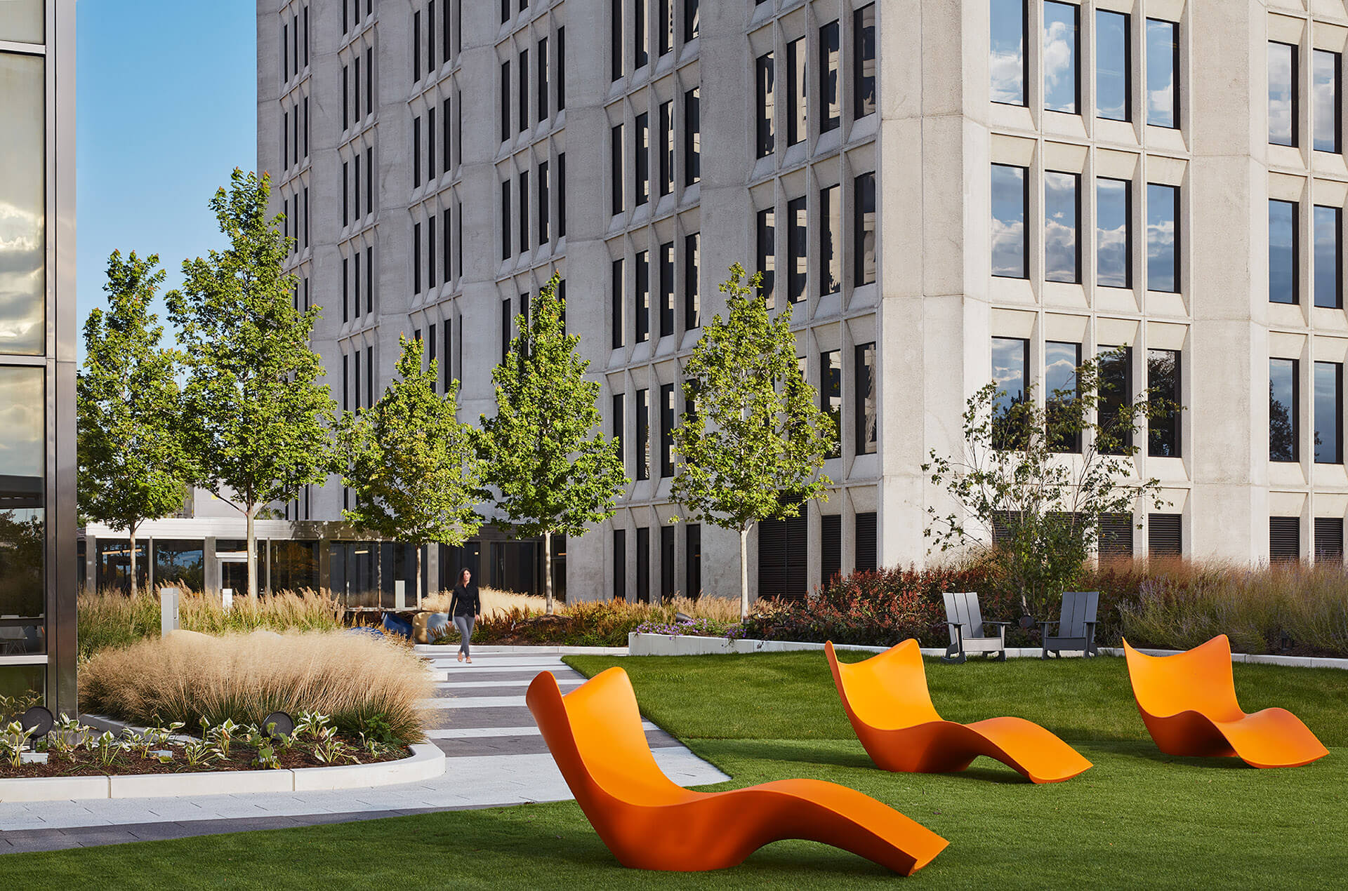 Lawn area outside continental towers with modern orange lounge chairs