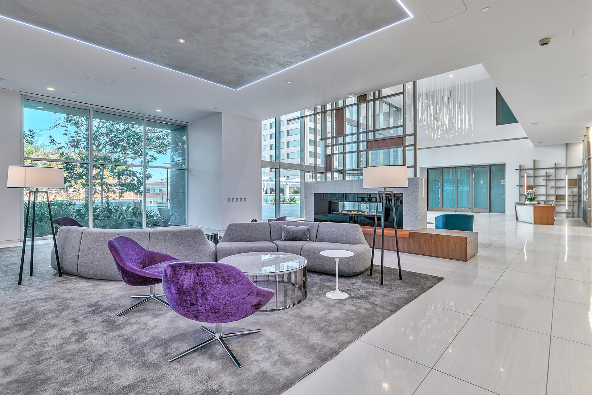 modern lobby with fireplace, couches and purple chairs at Energy Square building