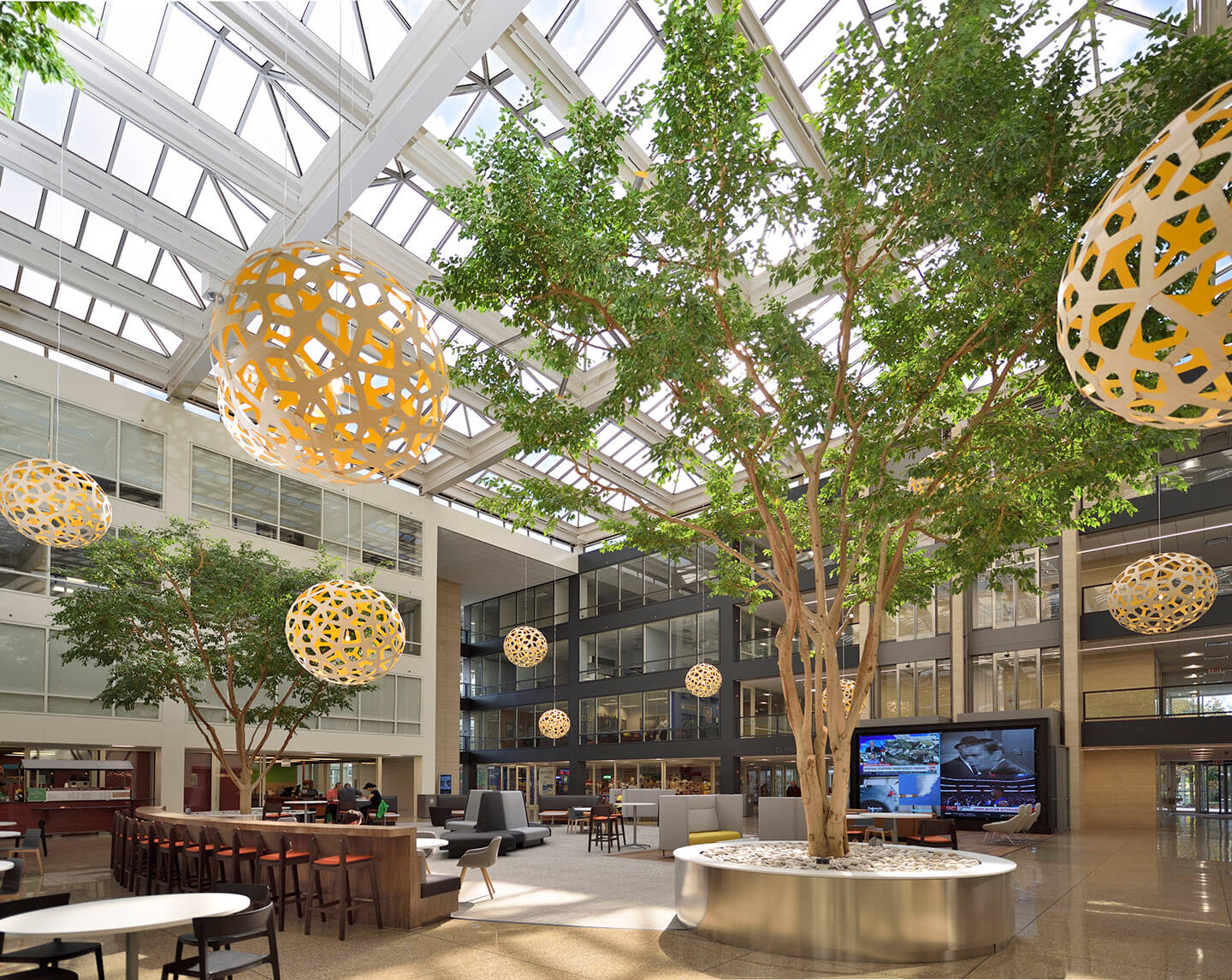 The light filled atrium of the schaumburg corporate center office building with yellow sphere sculptures hanging from ceiling