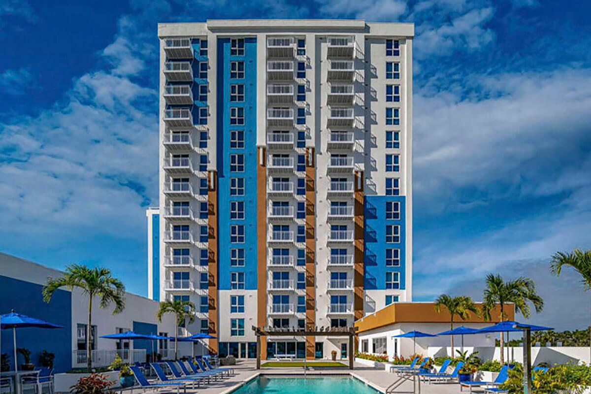 Apex 1100 multifamily building with a pool and lounge chairs.